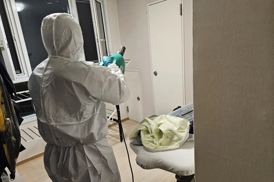 보호복과 분사 장비를 갖추고 실내를 관리하는 작업자